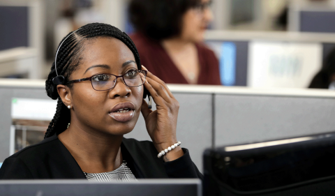 Woman customer service representative answering a call with her headset.